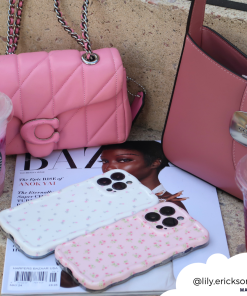 Two pink handbags and two Coconut Lane Wavy Phone Cases in Ditsy Floral White rest on top of a fashion magazine and a stone step. Beside them, there are two Starbucks drinks, one with a green straw and another with a purple hue. The Instagram tag 