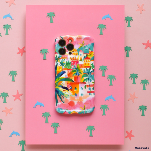 The Wavy Phone Case - Portofino Dreams by Coconut Lane is an extra protective phone case adorned with a vibrant tropical village design, featuring palm trees and houses. Set against a pink background dotted with small pastel palm tree, dolphin, and starfish icons, this case captures the coastal charm inspired by an Italian seaside getaway.