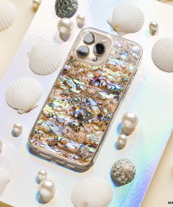 The Coconut Lane Real Natural Shell Phone Case - Black, showcasing an exquisite abalone shell-patterned design, is elegantly displayed on a reflective holographic surface. Surrounded by white seashells, spherical pearls, and textured grey stones, it crafts an immersive marine-inspired aesthetic.