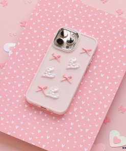 A Coconut Lane Pearly Hearts Phone Case - Pink, designed for the iPhone 15 and adorned with four white hearts and three pink bows, lies flat against a pink background featuring white heart patterns and scattered heart-shaped confetti. The phone's rear cameras are visible through cutouts in the case.