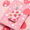 A Coconut Lane Wavy Phone Case - Berry Cute Strawberry with a delightful strawberry pattern and white flowers rests on a pink surface, surrounded by cut-out paper shapes of strawberries and flowers. The background includes larger pink strawberry shapes and smaller white flower shapes scattered around.