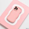 A strawberry-colored smartphone with a matching wavy-edged case rests on a pink and white abstract-patterned surface. The matte finish of the Coconut Lane NAKD Curvy Phone Case - Strawberry adds an elegant touch, while its highly protective design ensures the three-lens rear camera setup remains safe and secure.