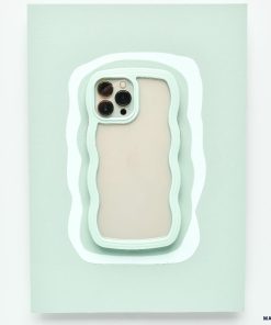 A mint green Curvy Phone Case - Mint by Coconut Lane with wavy edges holds an iPhone 15 featuring three cameras on the back. The protective case is set against a matching light green wavy background, creating a layered visual effect.
