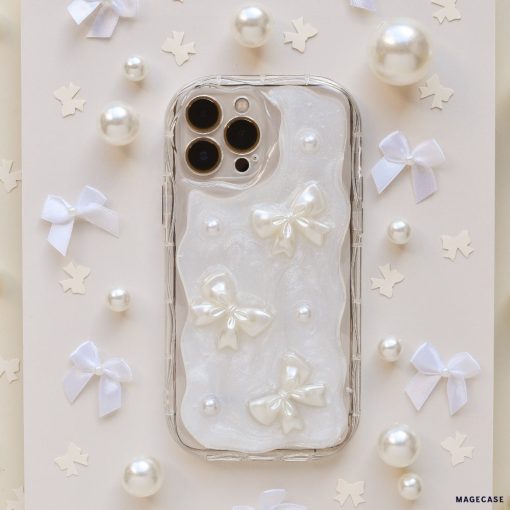 The Pearls & Bows Phone Case by Coconut Lane showcases a protective design adorned with iridescent white fabric, featuring elegant pearl-like bows and beads. The background is accentuated with petite, white bow-shaped ornaments and scattered pearl-like decorations, perfectly enhancing the sophisticated and delicate theme of this iPhone15 case.