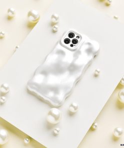 The 3D Pearl Phone Case - White from Coconut Lane, featuring a wavy texture and a glossy pearl white finish, is placed on a flat white surface surrounded by scattered pearls of various sizes. The case has precise openings for the camera and sensors at the top.