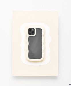 A highly protective Coconut Lane Curvy Phone Case - Cream, featuring a wavy design, is placed centrally on a rectangular surface layered to resemble paper cut-outs in various shades of white. The screen of the iPhone 15 is off, reflecting light slightly.