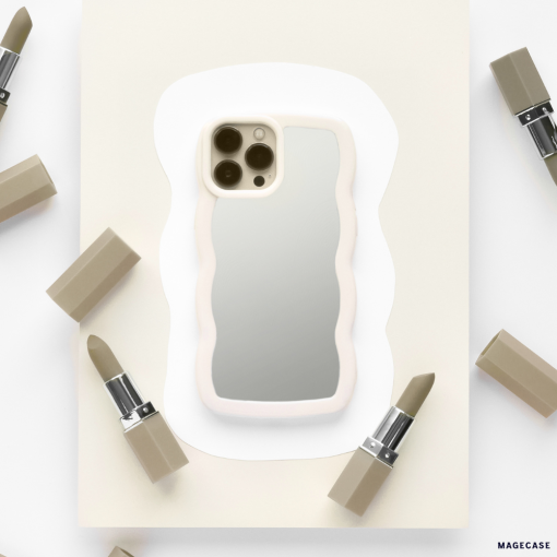 A sleek and stylish iPhone adorned with the Coconut Lane Curvy Mirror Phone Case in Cream is centered on a piece of off-white paper. The phone's camera is visible, reflecting off the back of the case. Surrounding the device are six muted beige lipsticks, some with their caps removed, arranged in a circular pattern.