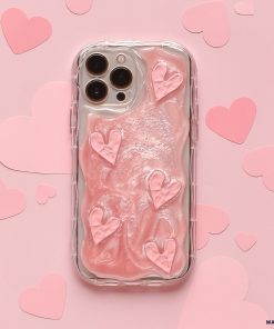 The Shimmer Pink Hearts Phone Case from Coconut Lane is a smartphone accessory that offers extra protection with its clear design, featuring raised, shimmer pink heart-shaped designs on a pink background. The background is adorned with cutout pink hearts, adding a romantic touch to the overall look.