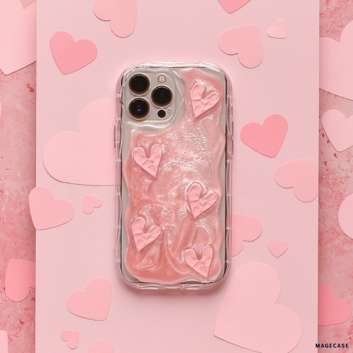 A Coconut Lane Shimmer Pink Hearts Phone Case, snugly fitting a smartphone, lies on a pink, textured background. Additional paper hearts in various shades of pink are scattered around the phone, creating a romantic, heart-themed scene.